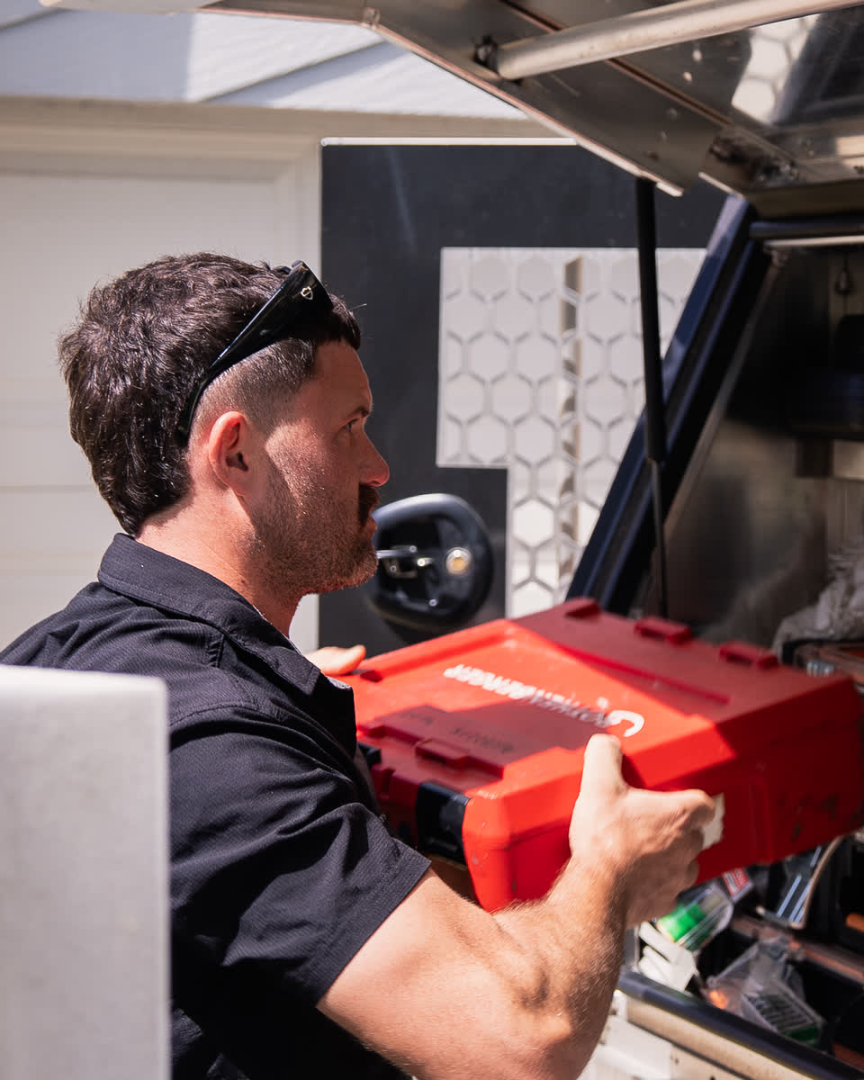 Joel taking a tool case from the fully stocked ute