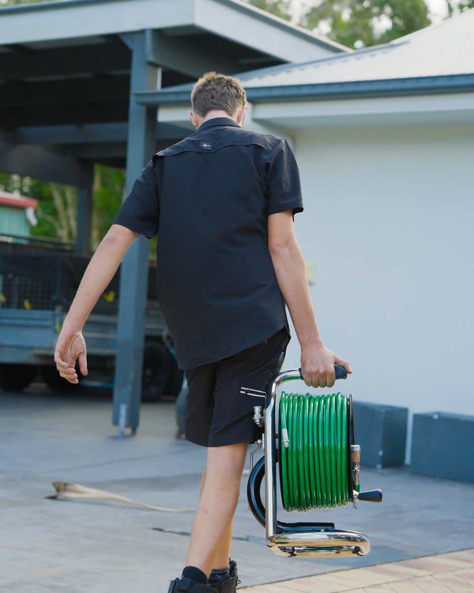 A member of the Oxplumb crew carrying a hose reel to a job