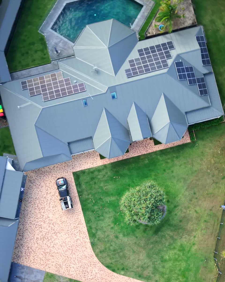 Aerial view of a home with solar panels and the Oxplumb ute in the driveway